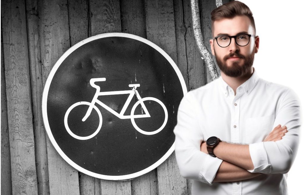 homme souriant, en arrière plan il y à un paneau attention vélo type code de la route