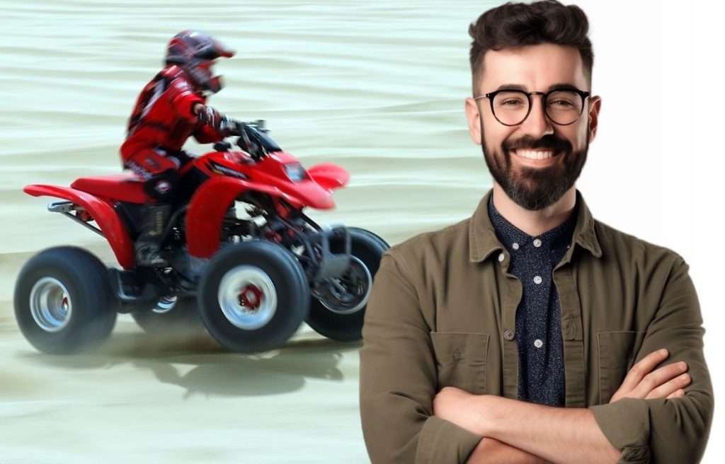 homme bras croisés souriant et en arrière plan il y à un home sur un quad qui roule dans l'eau.