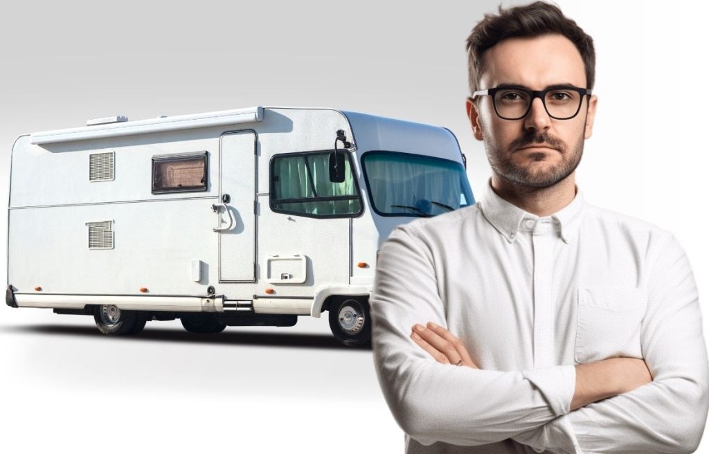 homme bras croisés qui vous regarde et derrière lui il y à un camping car blanc