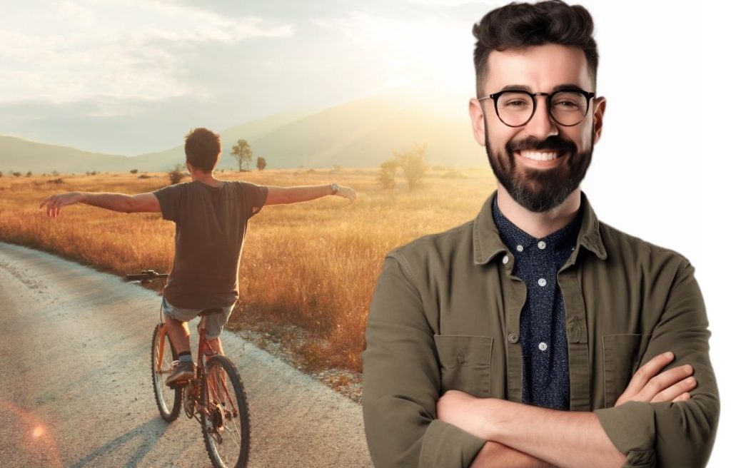 homme souriant à lunette avec les bras croisée face à vous et derrière lui un homme sur un vélo au couché du soleil qui étant ses bras sur les cotés